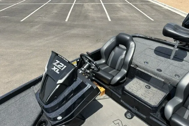 Slide: The Image of 2026 Nitro Z21 XL Pro boat interior with steering wheel and seating in a parking lot. - 24