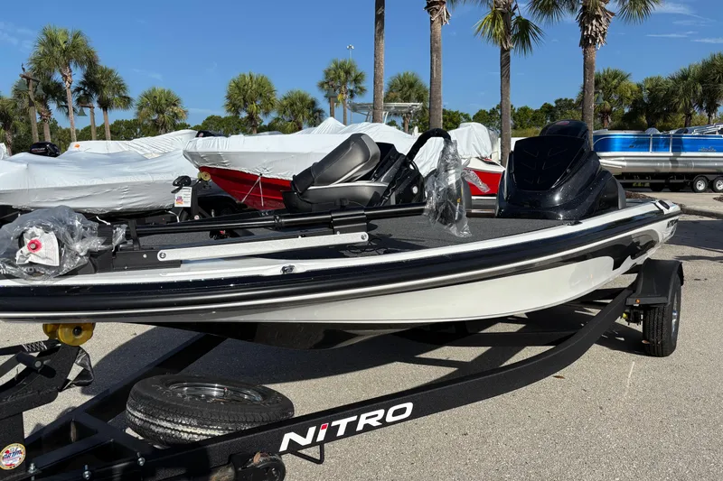 Slide: The Image of 2026 Nitro Z17 boat on trailer, surrounded by palm trees and other covered boats. - 91