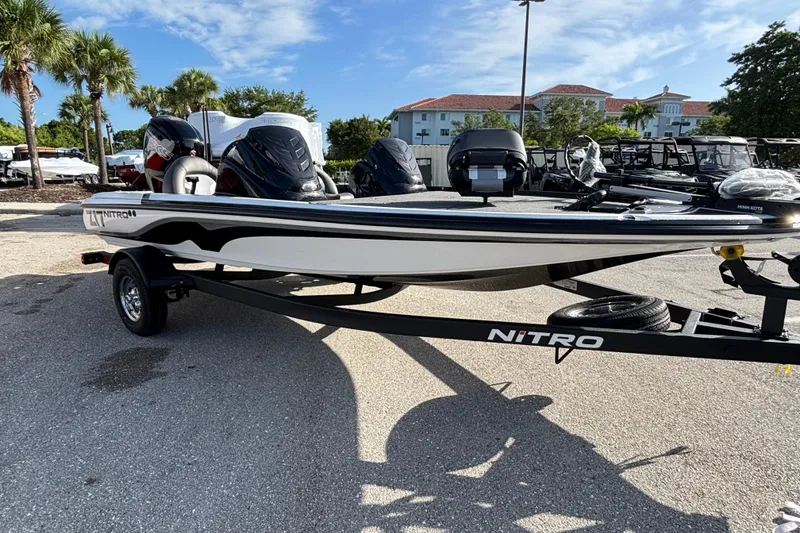 The Image of 2026 Nitro Z17 boat on trailer, parked outdoors with palm trees in the background. - 0