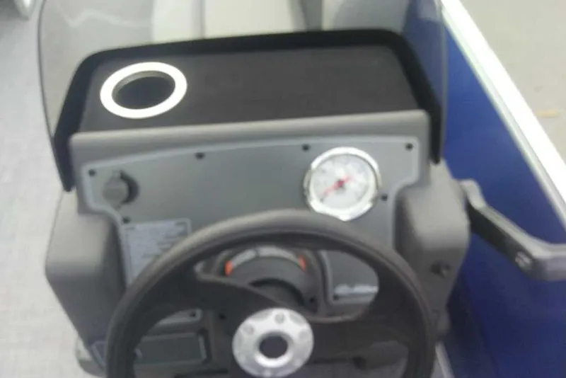 Slide: The Image of Steering console of 2026 Sun Tracker Party Barge 16 DLX with gauge and cup holder. - 11