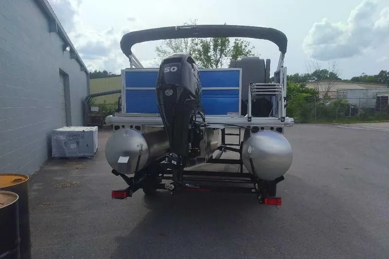 Slide: The Image of 2026 Sun Tracker Party Barge 16 DLX pontoon boat with outboard motor, parked outdoors. - 4