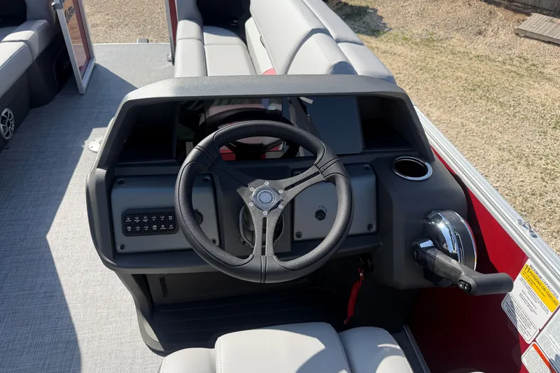 Slide: The Image of 2026 Sun Tracker Party Barge 22 DLX steering console with modern controls and seating. - 10