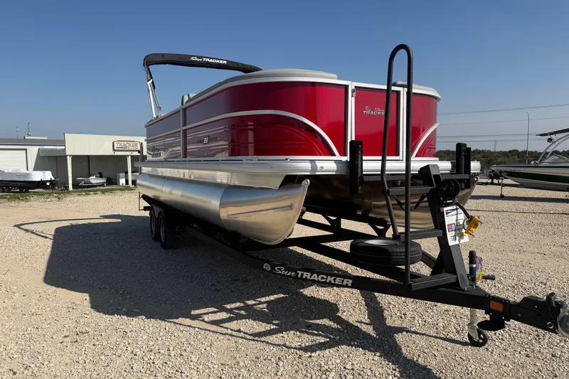 Slide: The Image of 2026 Sun Tracker Party Barge 22 DLX pontoon boat on trailer, parked outdoors. - 5
