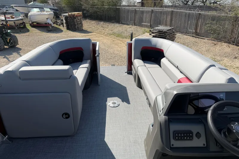 Slide: The Image of 2026 Sun Tracker Party Barge 22 DLX interior with gray seating and steering console. - 9