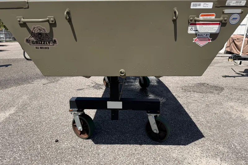 Slide: The Image of 2026 Tracker Grizzly 14 Jon boat on wheeled stand, outdoor setting. - 57