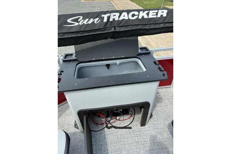 Slide: The Image of 2026 Sun Tracker SportFish 22 XP3 boat with open storage compartment and visible wiring. - 17