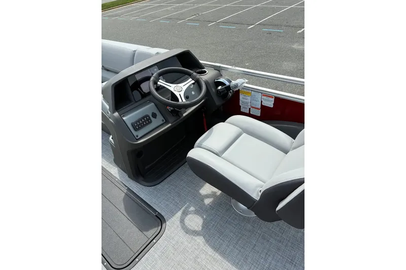 Slide: The Image of 2026 Sun Tracker SportFish 22 XP3 boat interior with steering wheel and captain's chair. - 13