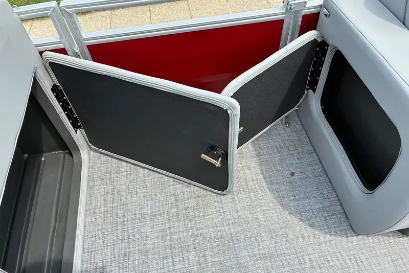 Slide: The Image of Open storage compartment on 2026 Sun Tracker SportFish 22 XP3 boat with gray flooring. - 12