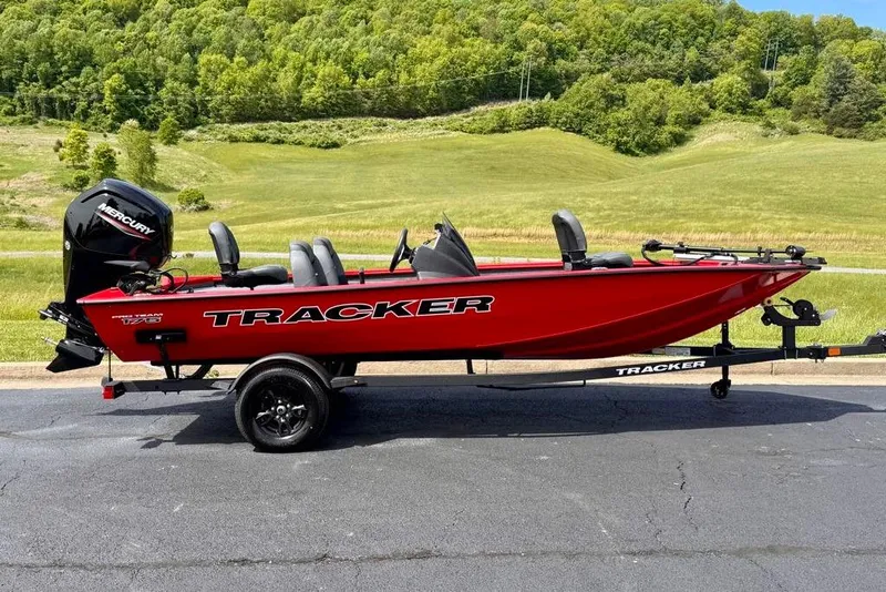 The Image of Red 2026 Tracker Pro Team 175 boat on trailer, set against a lush green landscape. - 0