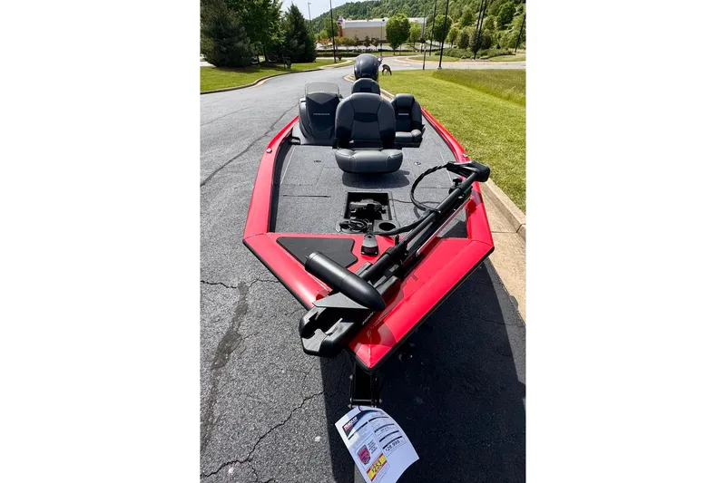 Slide: The Image of 2026 Tracker Pro Team 175 boat, red exterior, parked on pavement, featuring seating and fishing equipment. - 4