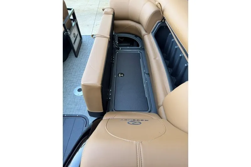 Slide: The Image of 2026 Regency 230 DL boat interior with tan seating and storage compartment. - 19