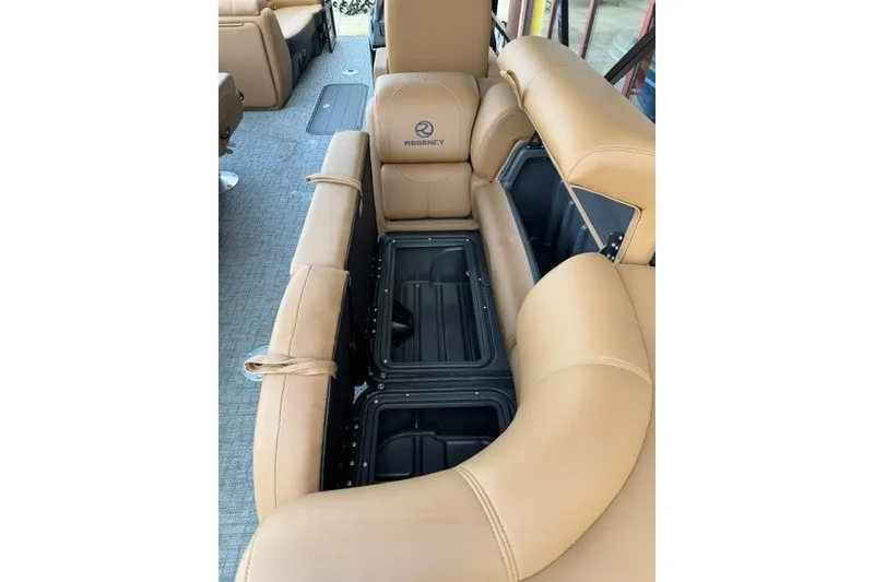 Slide: The Image of 2026 Regency 230 DL boat interior with tan leather seating and storage compartments. - 16