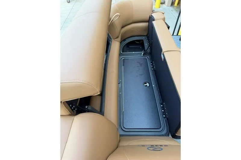 Slide: The Image of 2026 Regency 230 DL boat interior with tan leather seating and storage compartment. - 17