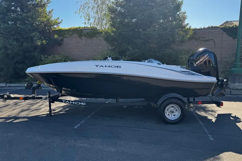 Slide: The Image of 2026 Tahoe T16 boat on trailer, parked outdoors, side view. - 1