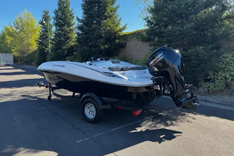 Slide: The Image of 2026 Tahoe T16 boat with Mercury engine, parked outdoors on a sunny day. - 5