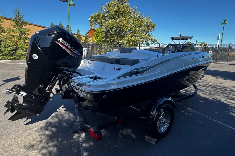 Slide: The Image of 2026 Tahoe T16 boat with Mercury engine, parked outdoors on a sunny day. - 4