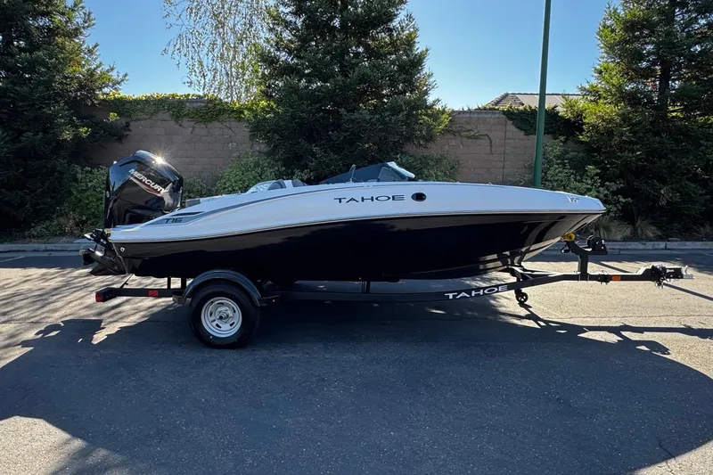 The Image of 2026 Tahoe T16 boat on trailer, parked outdoors, side view. - 0