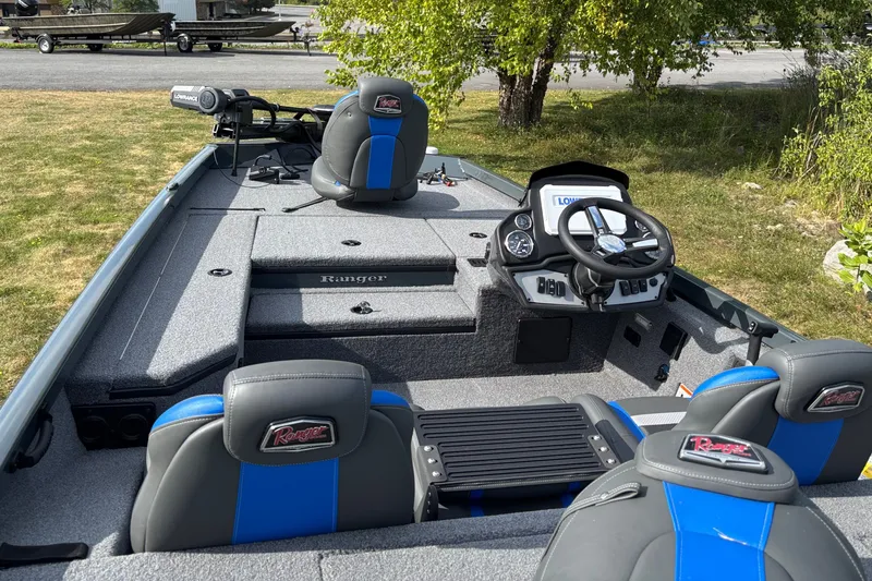 Slide: The Image of 2026 Ranger RT178 boat interior with steering console and seating, parked on grass. - 1