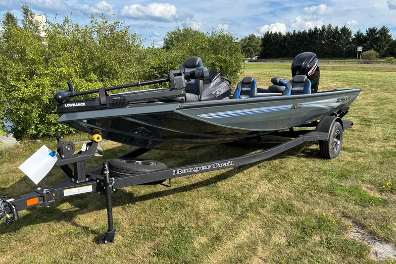 Slide: The Image of 2026 Ranger RT178 fishing boat on trailer, parked on grassy area under blue sky. - 2