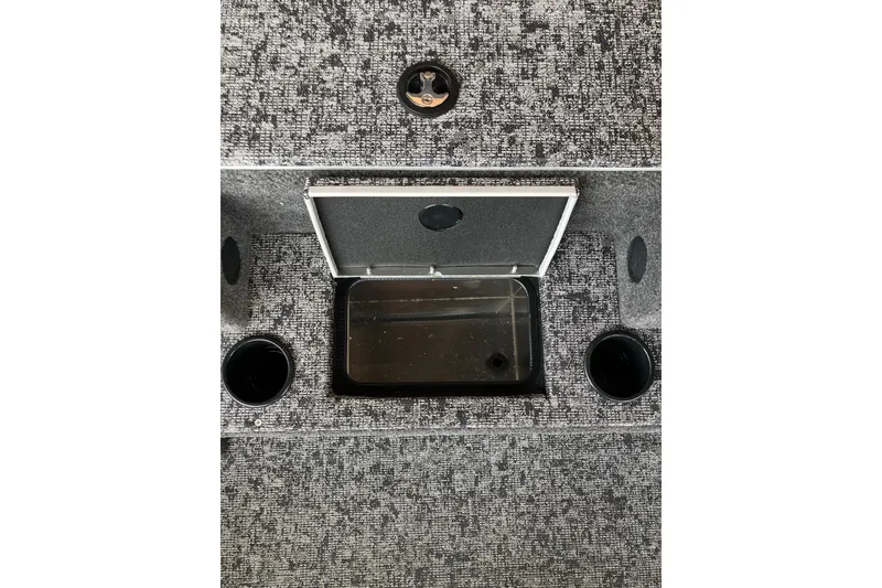 Slide: The Image of 2026 Tracker Pro Team 195 boat interior with open storage compartment and cup holders. - 8