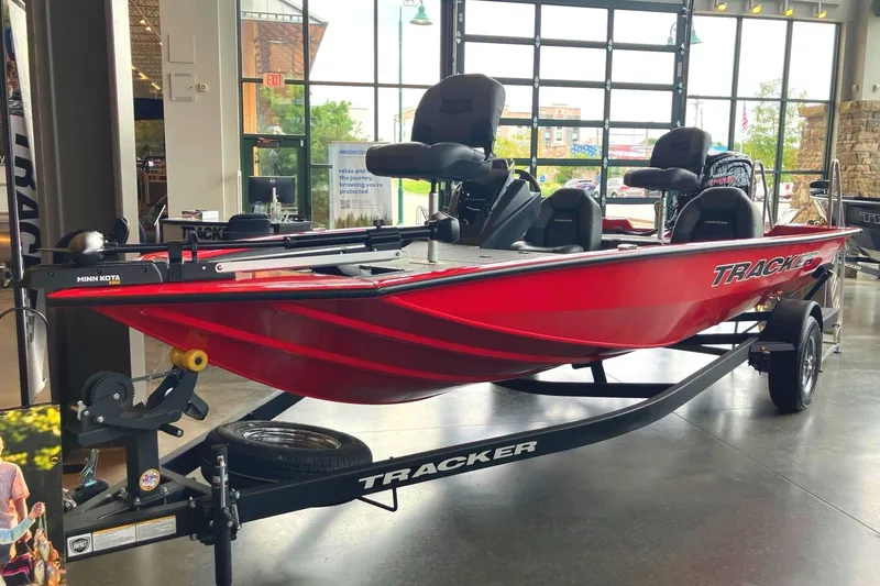 The Image of A red Tracker Pro Team 195 boat from 2026 is displayed in a showroom on a trailer. - 0