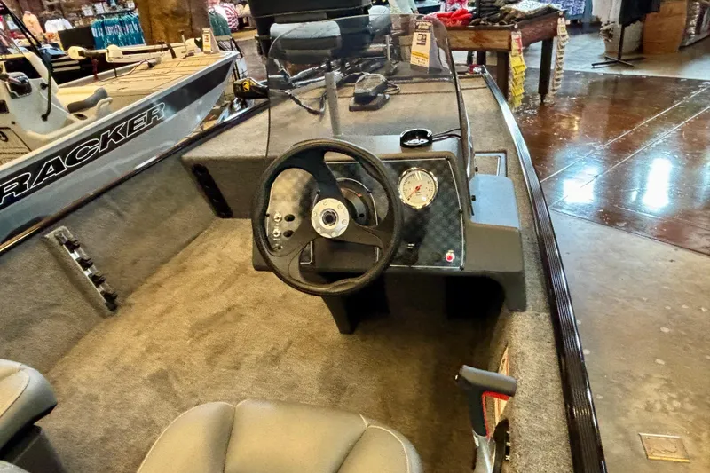 Slide: The Image of 2026 Tracker Bass Tracker Classic XL boat interior with steering wheel and dashboard display. - 3