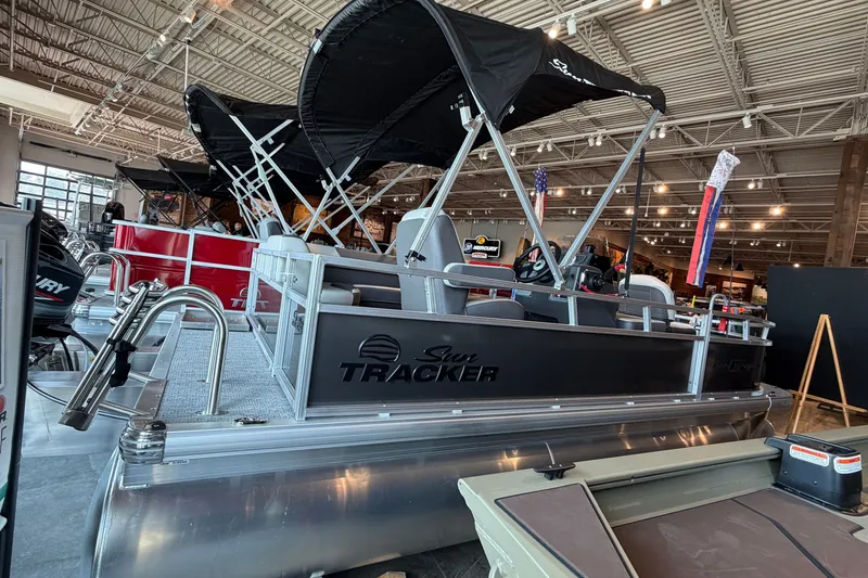 The Image of 2026 Sun Tracker Bass Buggy 16 XL Select pontoon boat displayed in showroom. - 0