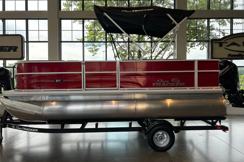 The Image of 2026 Sun Tracker Party Barge 18 DLX pontoon boat in showroom, side view. - 0