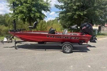 The Image of 2026 Tracker Pro Team 190 boat on trailer, parked outdoors, surrounded by trees. - 0