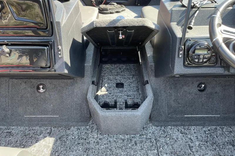 Slide: The Image of 2026 Tracker Targa V-18 Combo boat interior with open storage compartment and control panel. - 14