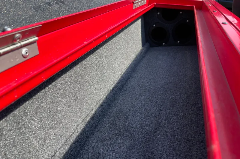 Slide: The Image of Interior storage compartment of 2026 Tracker Targa V-18 Combo boat, featuring red trim. - 26