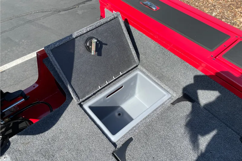 Slide: The Image of 2026 Tracker Targa V-18 Combo boat with open storage compartment, red and gray interior. - 21