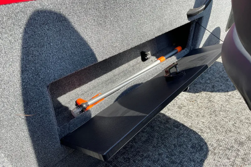 Slide: The Image of Storage compartment in 2026 Tracker Targa V-18 Combo boat, featuring secure latch and rod holder. - 28