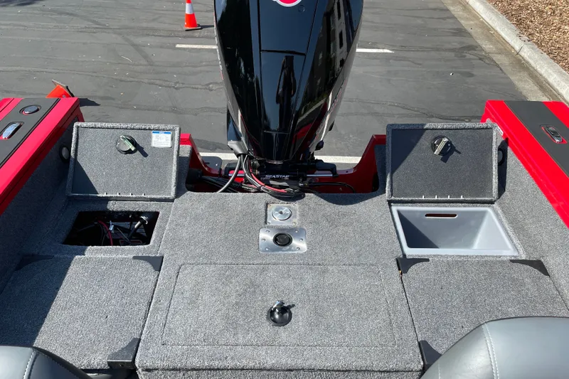Slide: The Image of 2026 Tracker Targa V-18 Combo boat interior with open storage compartments and motor. - 22