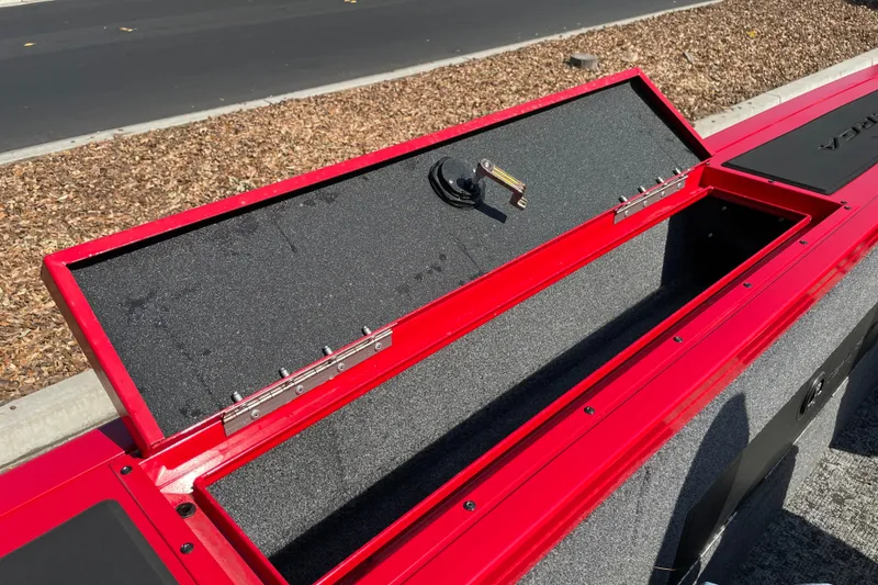 Slide: The Image of Open storage compartment on 2026 Tracker Targa V-18 Combo boat, featuring red exterior. - 25