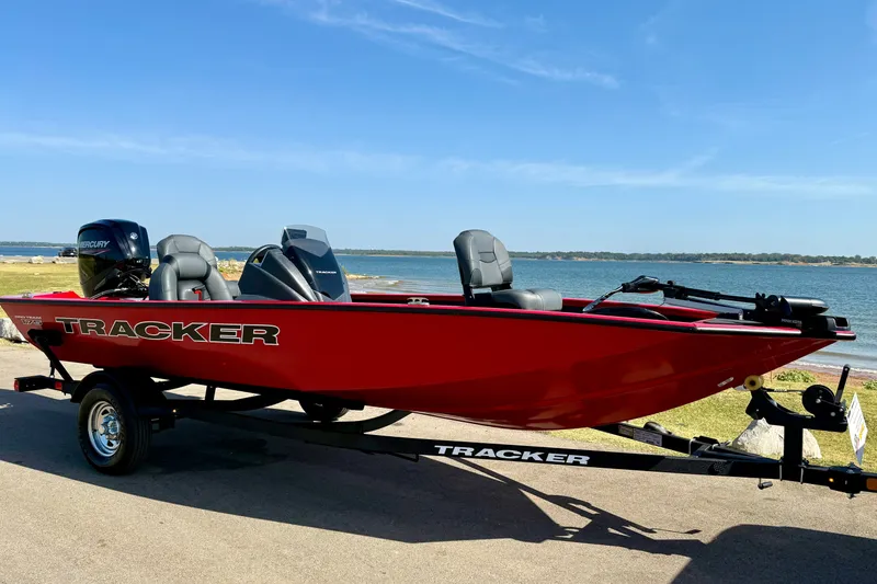 The Image of 2026 Tracker Pro Team 175 boat in vibrant red by a scenic lakeside. - 0