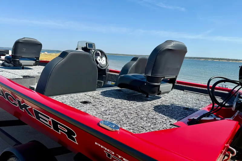 Slide: The Image of 2026 Tracker Pro Team 175 boat with red exterior, on a lake under clear blue sky. - 14