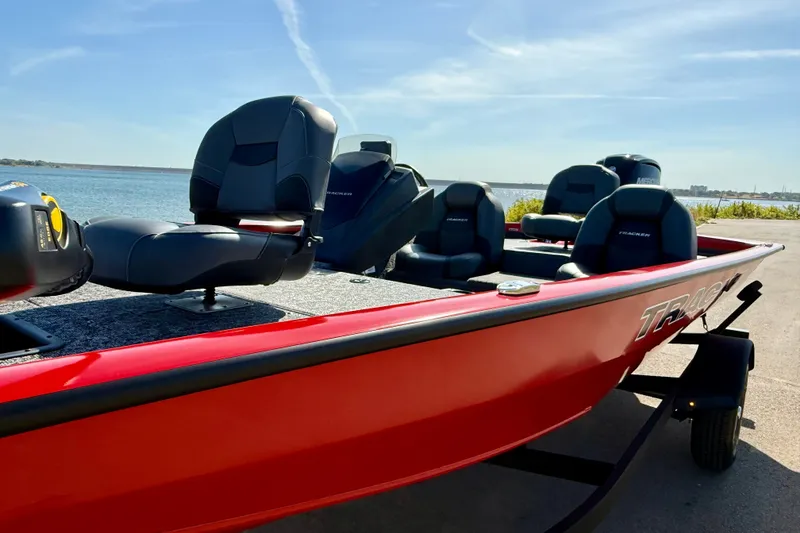 Slide: The Image of 2026 Tracker Pro Team 175 boat with red exterior, docked by a serene lake. - 19