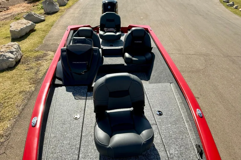 Slide: The Image of 2026 Tracker Pro Team 175 boat with red exterior and gray seating on a paved road. - 18