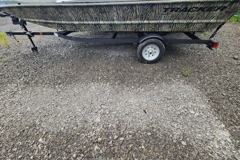 The Image of 2026 Tracker Grizzly 1648 Utility boat on a gravel surface, side view. - 0