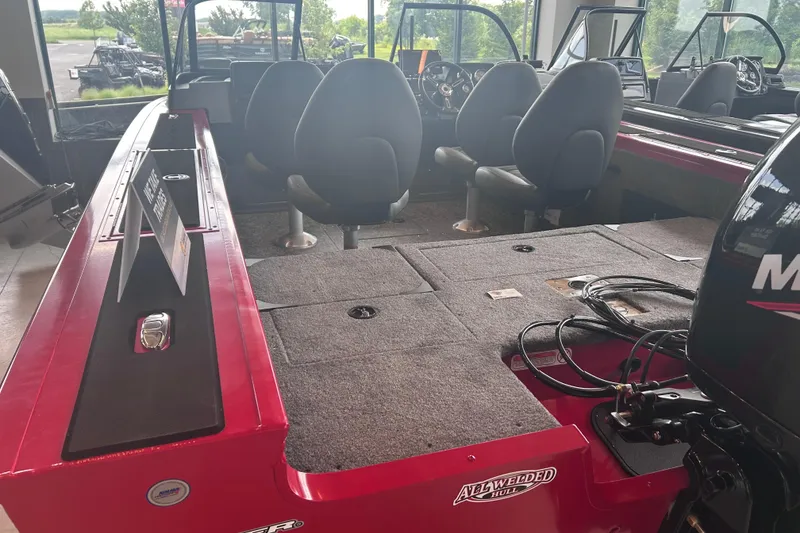 Slide: The Image of 2026 Tracker Targa V-18 Combo boat interior with seating and motor, displayed indoors. - 9