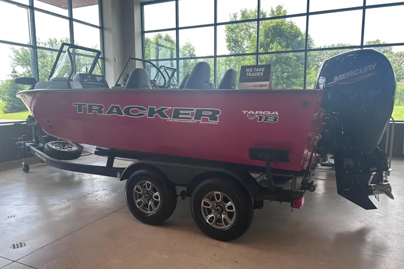 The Image of 2026 Tracker Targa V-18 Combo boat on trailer in showroom with Mercury engine. - 0
