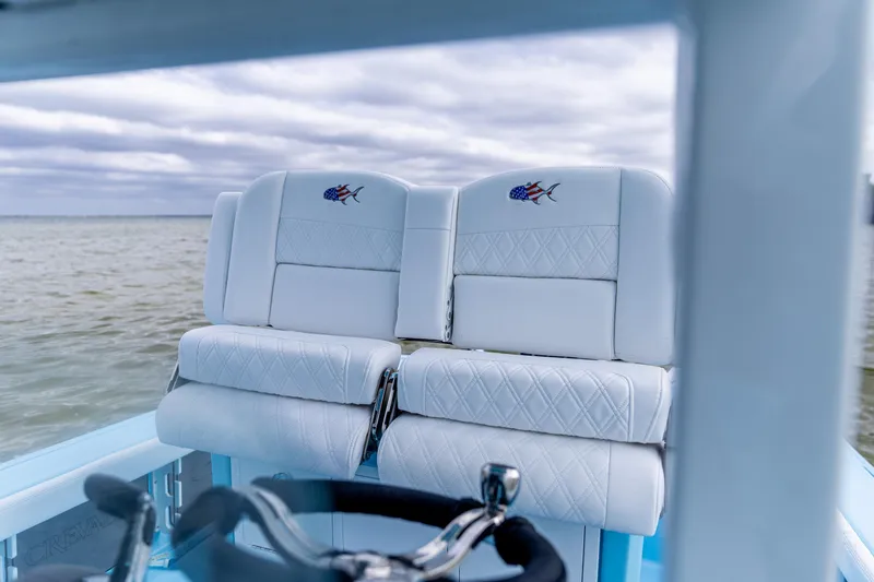Slide: The Image of Luxurious seating on 2026 Crevalle 26 HCO boat with embroidered design, ocean backdrop. - 10