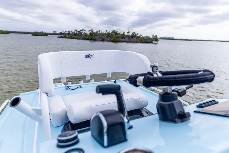 Slide: The Image of 2026 Crevalle 26 HCO boat interior with steering wheel and seating, on calm water. - 11