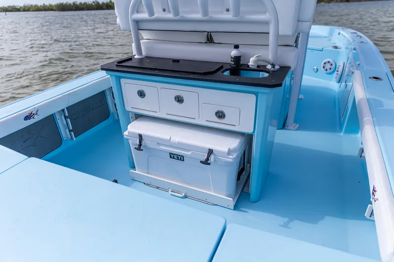 Slide: The Image of 2026 Crevalle 26 HCO boat interior with storage and cooler on a calm lake. - 14