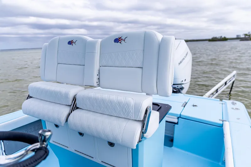 Slide: The Image of 2026 Crevalle 26 HCO boat with white cushioned seats on a calm water backdrop. - 5