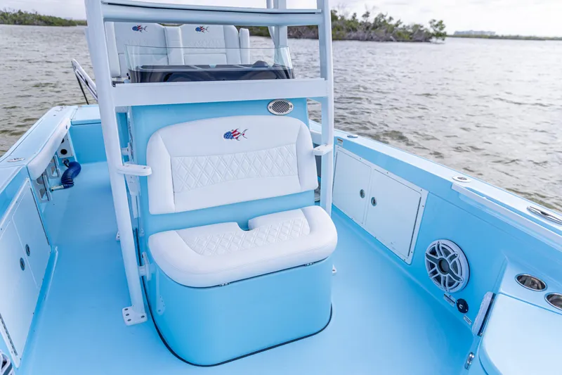 Slide: The Image of 2026 Crevalle 26 HCO boat interior with blue and white seating, on calm water. - 7