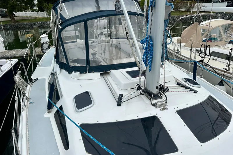Slide: The Image of 2002 Hunter Passage 420 sailboat docked, featuring a sleek deck and blue canopy. - 12