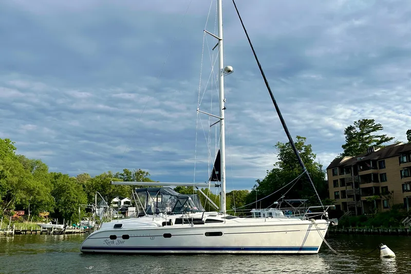 Slide: The Image of Hunter Passage 420 sailboat from 2002 docked near waterfront buildings. - 2