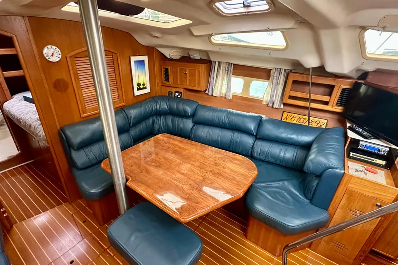 Slide: The Image of Interior of 2002 Hunter Passage 420 yacht with blue seating and wooden table. - 22